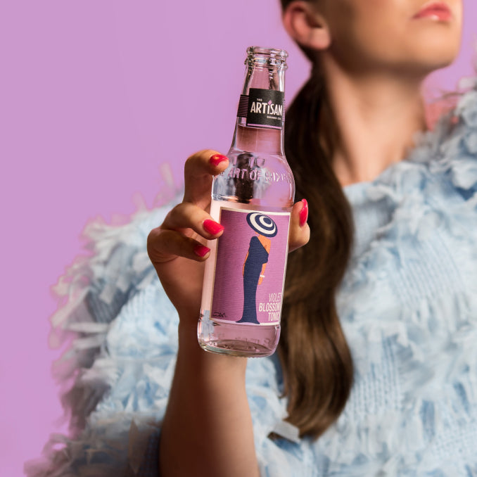 Close up of woman holding bottle of Violet Blossom Tonic 